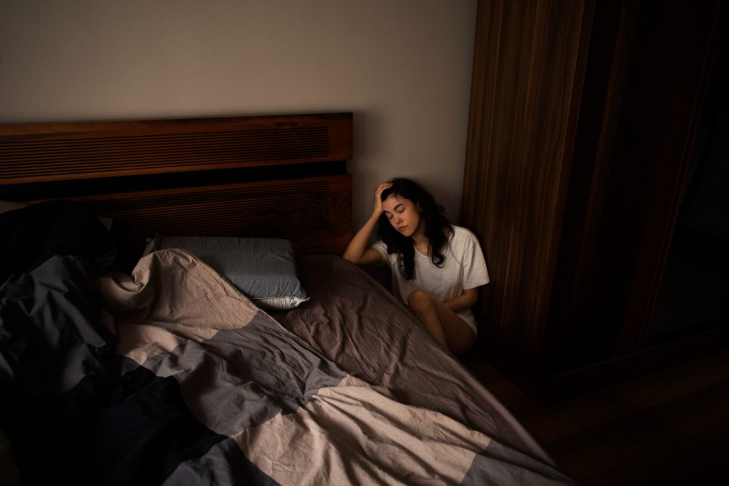 Mulher jovem não consegue dormir por causa do colchão