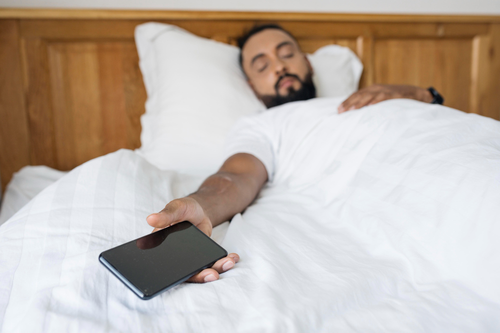 Homem branco dormindo com o celular na mão